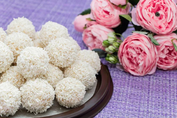 Coconut candy pyramid on a background of flowers