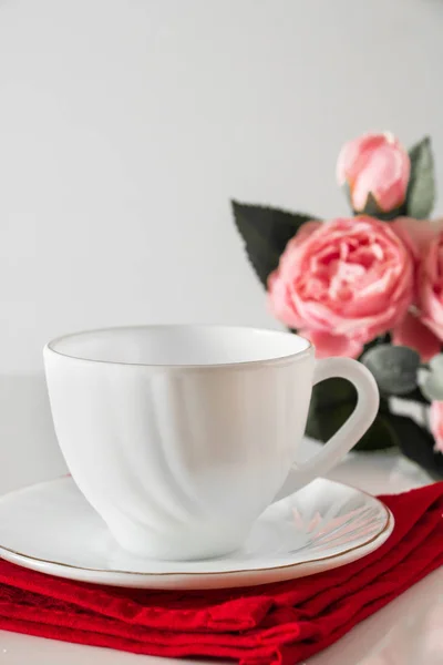 Weiße Kaffeetasse Auf Roter Serviette Vor Rosa Blüten Lichtschlüssel Liebeskonzept — Stockfoto