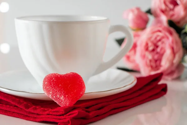 Weiße Kaffeetasse Auf Roter Serviette Vor Rosa Blüten Lichtschlüssel Liebeskonzept — Stockfoto