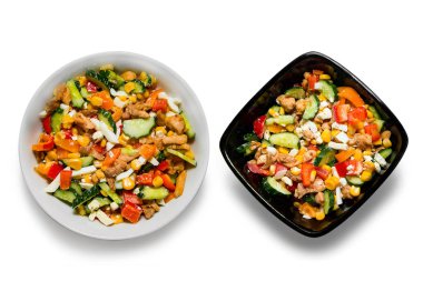 Beyaz arka planda izole edilmiş beyaz bir tabakta parlak sebze salatası. Lezzetli bir diyet salatası pişiriyorum. İki kase sebze salatası ve beyaz arka planda izole edilmiş tavuk.