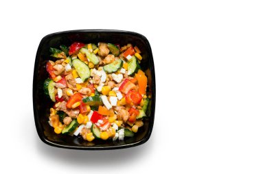 Beyaz arka planda izole edilmiş siyah tabakta tavuklu lezzetli sebze salatası. Metin için yer, üst görünüm