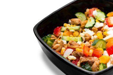 Beyaz arka planda izole edilmiş siyah tabakta tavuklu lezzetli sebze salatası. Parlak sebze salatalı siyah kase ve beyaz arka planda izole edilmiş yakın plan tavuk.