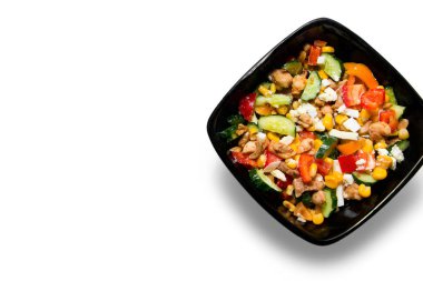 Lezzetli sebze salatası. Tavuklu. Beyaz arka planda izole edilmiş siyah bir kâseye yakın.