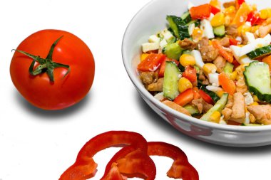 Lezzetli bir diyet salatası pişiriyorum. Beyaz arka plandaki malzemelerin yanında sebze salatası tabağı.