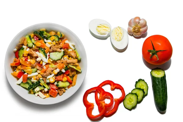 Beyaz arka planda izole edilmiş beyaz bir tabakta parlak sebze salatası..