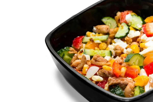 Beyaz arka planda izole edilmiş siyah tabakta tavuklu lezzetli sebze salatası. Parlak sebze salatalı siyah kase ve beyaz arka planda izole edilmiş yakın plan tavuk.