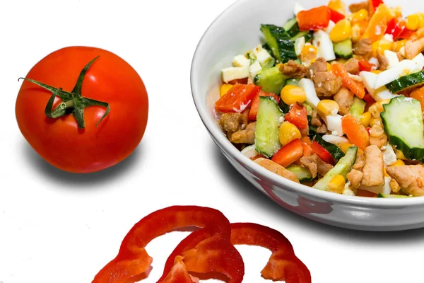 Lezzetli bir diyet salatası pişiriyorum. Beyaz arka plandaki malzemelerin yanında sebze salatası tabağı.