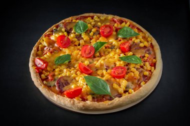 Siyah arka planda domatesli ve fesleğenli büyük İtalyan pizzası. Siyah arka planda vişneli, peynirli ve yeşil fesleğenli büyük pizza. Ulusal İtalyan yemeği Akdeniz mutfağı. Üst görünüm, metin için yer.