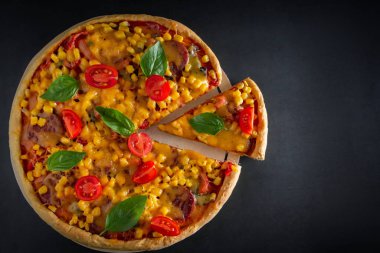 Siyah arka planda domatesli ve fesleğenli büyük İtalyan pizzası. Siyah arka planda vişneli, peynirli ve yeşil fesleğenli büyük pizza. Ulusal İtalyan yemeği Akdeniz mutfağı. Üst görünüm, metin için yer.