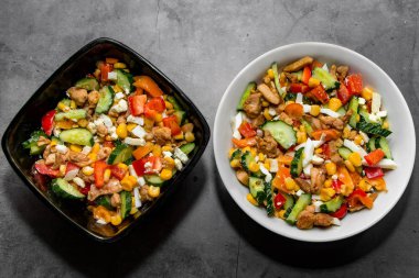 Gri arka planda doğru beslenmek için iki kase sebze salatası.