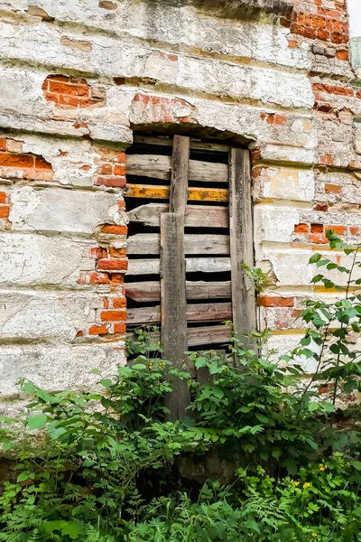A boarded up window in an old abandoned building. The building of an old abandoned estate of the 18th century with boarded up windows
