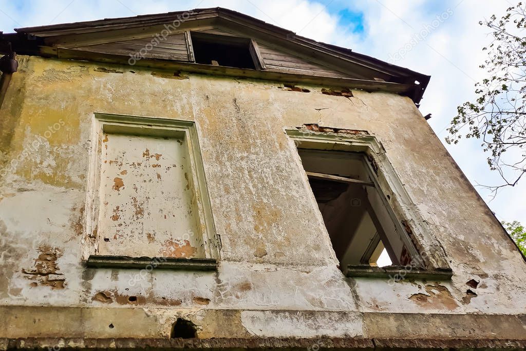 Old abandoned manor house with boarded up windows. The building of an old abandoned estate of the 18th century with boarded up windows