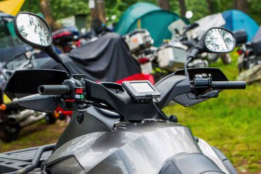 Yeşillikler arasında doğada motosiklet. Bir moto kampındaki çadırların arka planında motosiklet görüntüsü