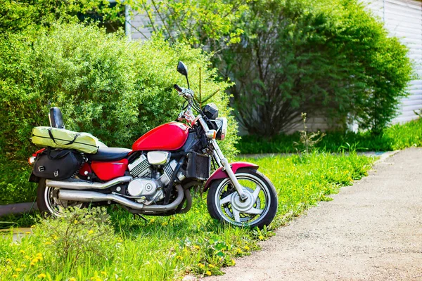 摩托车在自然界的绿色中 一辆红色摩托车停在绿色的草坪上 — 图库照片