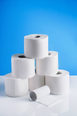 Mavi arka planda tuvalet kağıdı ruloları. Gerekli malların panik içinde alınması. Dünyadaki koronavirüs salgını..