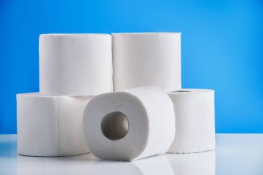 Mavi arka planda tuvalet kağıdı ruloları. Gerekli malların panik içinde alınması. Dünyadaki koronavirüs salgını. Süpermarkette mal sıkıntısı var..