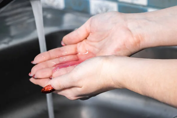 A woman washes and disinfects her hands with soap. Coronavirus protection. Step-by-step instructions for handwashing. Personal hygiene and healthcare.