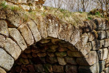 Nehrin üzerinde mavi gökyüzüne karşı kadim kemerli taş köprü. Klasik Romanesk mimari.