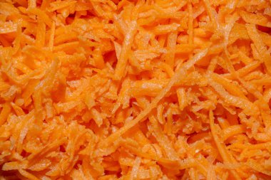 Rendelenmiş havuçlar yakından. Parçalanmış portakal sebzelerinin arka planı.