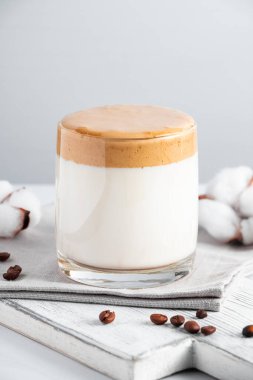 Moda Kore içeceği, dalgona kahvesi. Hafif arka planda köpüklü bir bardak buzlu süt. Dikey fotoğraf