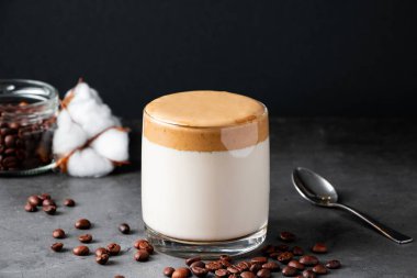 Siyah arka planda Dalgona kahvesi. Modaya uygun bir içki hazırlıyorum. Buzlu sütle doldurulmuş yumuşak, tatlı bir köpük..