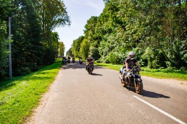 Güneşli bir yaz gününde motosikletçiler yollara düşer. Bir motosiklet sütunu bir motor festivaline gidiyor: 08.24.2019 - Lida, Belarus.
