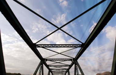 Bulutlu gökyüzü ve güneş ışığı ray ile modern köprü yapısı