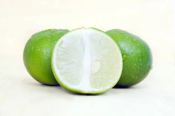 Limão ou limão com metade da secção transversal e parte da secção — Fotografia de Stock