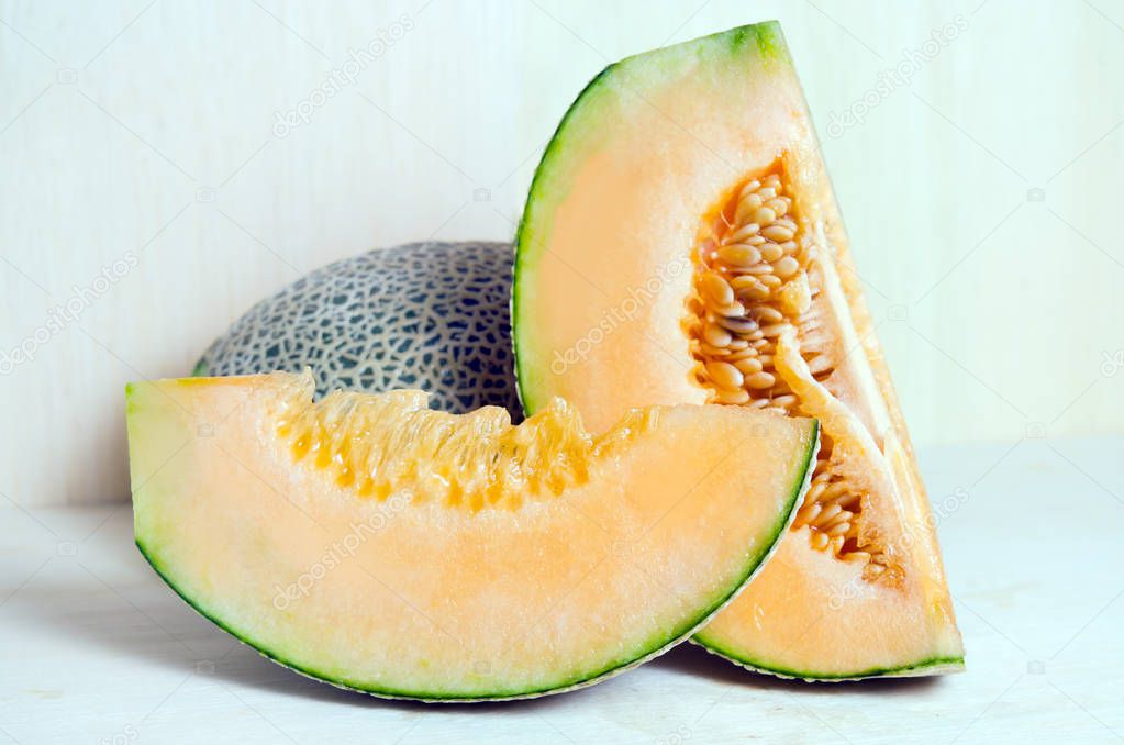 Cucumis melo or melon with half and seeds on wooden plate 