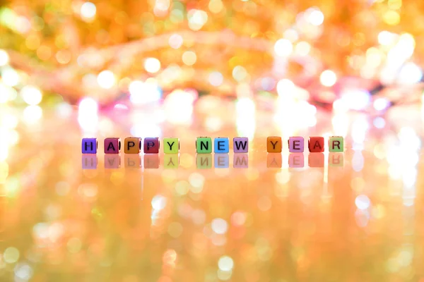 Šťastný nový rok text a teplé světlé pozadí s podlahou reflexe — Stock fotografie
