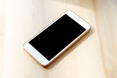 ahşap masa arka planda sabah ile akıllı telefon 