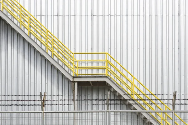 De gele Brandtrap trap met de fabrieksgebouw — Stockfoto