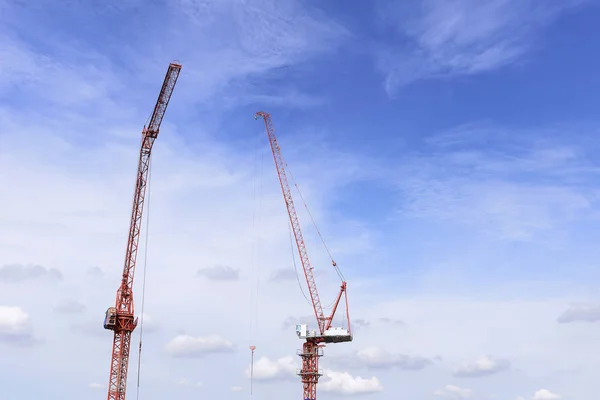 O braço vermelho do guindaste de construção com o céu azul . — Fotografia de Stock