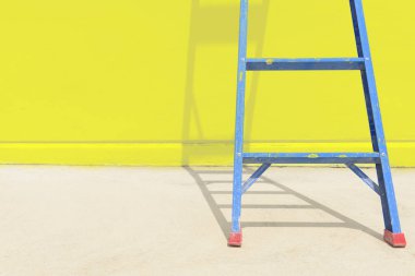 Sarı beton duvar ile mavi çelik merdiven