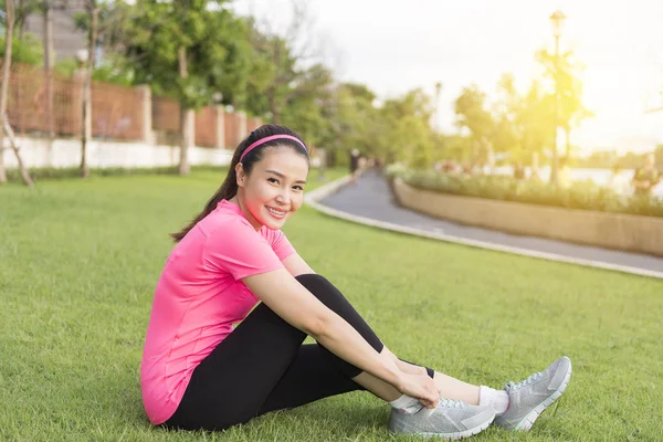 The pretty women wear the shoes before jogging  in the park. — Stock Photo, Image