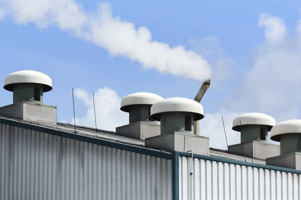 De schoorsteen op het dak van het fabrieksgebouw. — Stockfoto