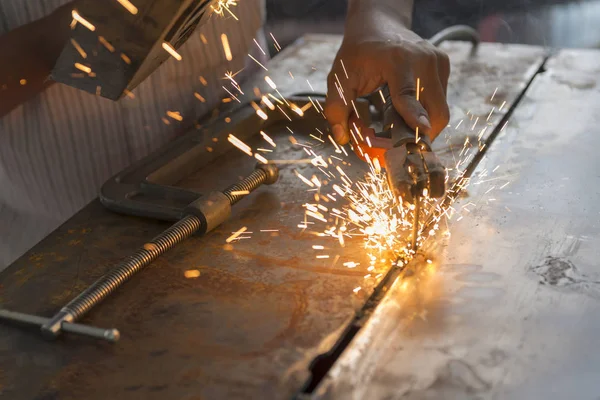 The worker welding the metal plate