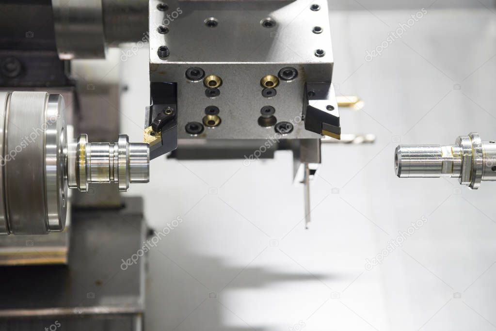 The  CNC lathe machine cutting the  metal shaft 