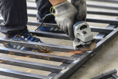 İşçi El değirmeni makine kullanmak 