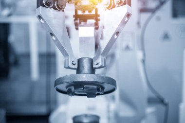 Robotik kol metal döküm parçalarını tutar.