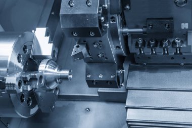 Metal çalışma sürecindeki Cnc torna makinesi açık mavi sahnede metal koni şeklindeki parçaların ucunu kesiyor. Cnc dönüşüm makinesi tarafından çalışan yüksek teknolojili metal işleme .