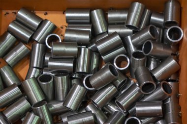 Konteynır kutusundaki işlemden sonra mekanik tüpler yığını. Cnc torna makinesinden yüksek teknoloji metal çalışma süreci.