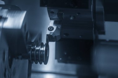 Cnc torna makinesi kanalı makara parçalarını kesmek için bir araç kesiyor. Cnc dönüşüm makinesinin yüksek teknolojili otomotiv parçaları üretim süreci .