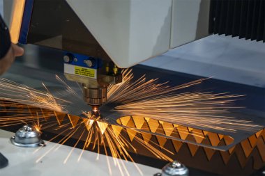 Fiber lazer kesme makinesi parlak ışıkla metal levhayı kesiyor. Lazer kesme makinesinin yüksek teknoloji metal üretim süreci.. 