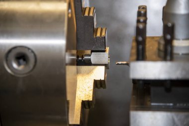 Torna makinesinin metal şaft parçalarını kesmesi. Makineyi döndürerek metal işleme süreci.