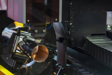 Fiber lazer kesme makinesi CNC programının paslanmaz çelik tüp kontrolünü kesiyor. Lazer kesme makinesiyle çalışan metal levha, paslanmaz çelik boru parçalarını oyuyor..