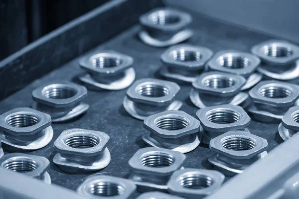 Açık mavi sahnedeki inşaat endüstrisinin özel amacı için özel fındık. Gevşek ceviz ve cıvata üretimi endüstrisi konsepti..