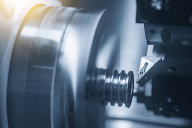 CNC torna makinesi kanalı aydınlatma efektiyle metal makara parçalarını kesiyor. CNC dönüşüm makinesinin yüksek teknolojili metal işlemesi .