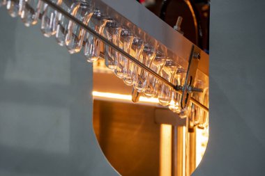 Üretim hattında otomatik üfleme makinesine giden tüp önceden biçimlendirilmiş ısıtma işlemi. PET şişe işleme işlemi üfleme kalıbı ile işlem. 