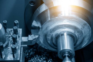 Torna makinesinin kullanımı, açık mavi sahnede aydınlatma efektiyle metal parçaları kaba kesme işlemi. Makineyi döndürerek metal işleme süreci.